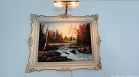 Front view showing entire framed painting and attached lamp