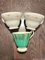 Front view of three teacups showing designs