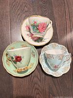 All three teacup and saucer sets displayed on wooden surface