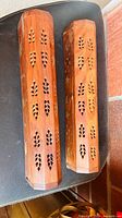 Top view of both wooden incense burner boxes showing carved cut-outs and brass inlay