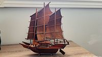 Port side view of wooden model sailboat on table