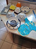 Overview of all ceramic pieces and bottle cover on countertop