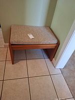 Full view of teak bench against wall