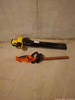 Overall view of blower and hedge trimmer on floor