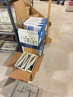 Hammermill paper cases stacked next to open box of binders