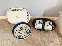 rectangular platter, round plate, oval dish with two mugs displayed