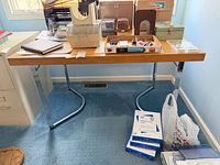 Full front view of desk showing wood top and chrome legs