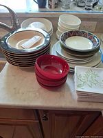 Stacks of assorted plates and bowls on countertop