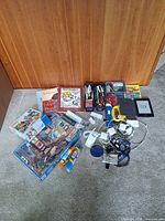 Overall view of Kindle, cables, jigsaw puzzle, puzzle books, Pez refills, pens and office supplies