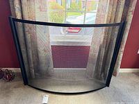 Front view of curved black metal fireplace screen