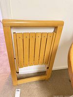 Chair folded upright showing full frame and slatted back