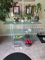 Front view of shelving unit showing three frosted glass shelves and metal supports