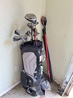Bag with clubs and two red-shafted clubs leaning