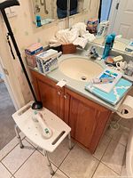 Shower bench, cane, boxed grab bar and assorted bathroom items on vanity