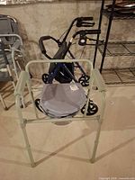 Front view of bedside commode, rollator walker visible behind