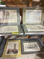 Overview of six framed university prints on shelving