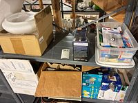 Shelf with glass lamp shade, cardboard boxes and bin of bulb packages