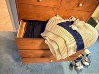 Drawer showing cream knit blanket with navy stripe and dark navy textile blanket