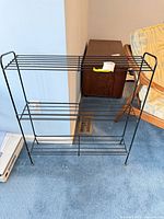 Front view of black metal rack showing full structure and shelves