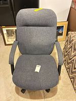 Front view of grey upholstered adjustable office chair showing seat, backrest, armrests, wheeled base