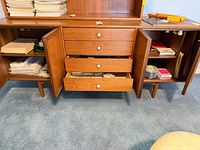 Wide view of cabinet interior showing drawers and shelves containing assorted office supplies