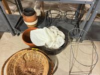 Group shot of metal stands, wicker baskets, planters