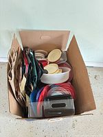 Top view of box showing variety of plastic lids, containers, reusable and paper bags