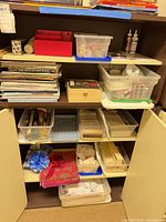 Five shelves with assorted sewing notions, magazines, bins and organizers