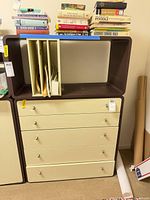 Full view of stacked drawer chest with open shelf and books on top