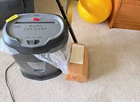 Staples shredder with liner bag installed, box of bags and yellow exercise ball nearby