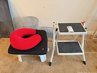 All items together: step stool, plastic stool with cushion, neck pillow on top, mesh wastebasket, mesh organizer