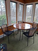 Round wood-top table with four matching woven-slat chairs