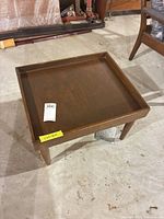Full view of square walnut side table with raised lip top and tapered legs