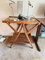 Full view of teak side table with two tiers and X-frame legs