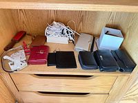 All items arranged on shelf showing variety of wallets, phone sleeve, shoelaces, accessories