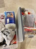 Two clear latching bins, one open showing yarn, one closed