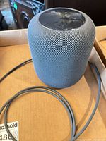 Space gray Apple HomePod smart speaker with power cable shown from side and top