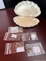 All five labeled bags of jewelry pieces beside open clam-shell jewelry box