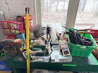 Overview of entire assortment showing brushes, pads, ties, cords on green surface