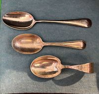 Top view of three silver children spoons side by side