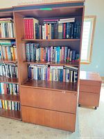 Front view of full bookcase with books (not included) showing shelves and two lower file drawers