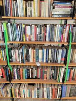 Three shelves of assorted books on metal shelving