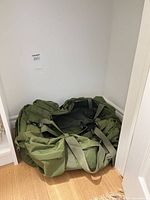 Full view of green canvas duffel bag in closet