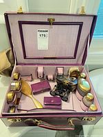 Open vanity case showing full contents including jars, brushes, binoculars, pouches