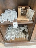 Two-shelf cabinet showing full assortment of glasses grouped by type