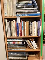 Three shelves filled with assorted hardcover books on birds, nature, art and fashion