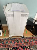 Front view of IQAir HealthPro Series air purifier with manual on top and attached power cord