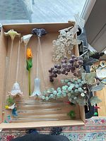 overall view of flowers, grape clusters, rods and fish in tray