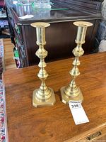 Pair of brass candlesticks on wooden surface