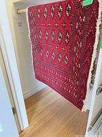 Rug hung to display red field and motifs